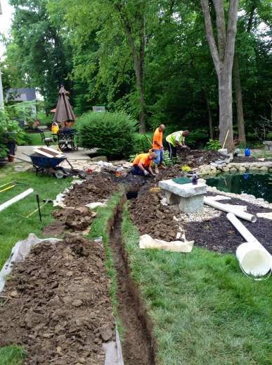 Dirt is carefully placed on tarps so as not to damage the grass