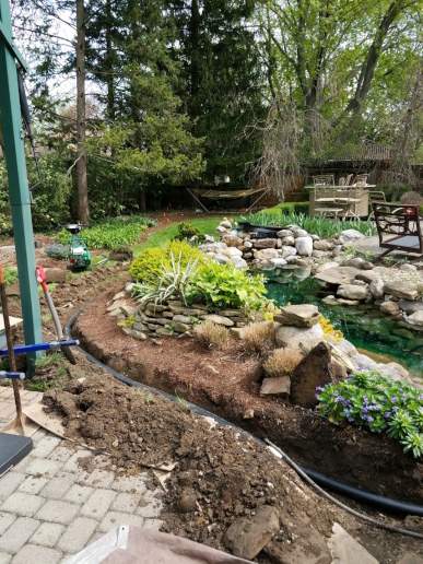All of the dirt is being placed back in the trench and compacted so the water garden looks new again